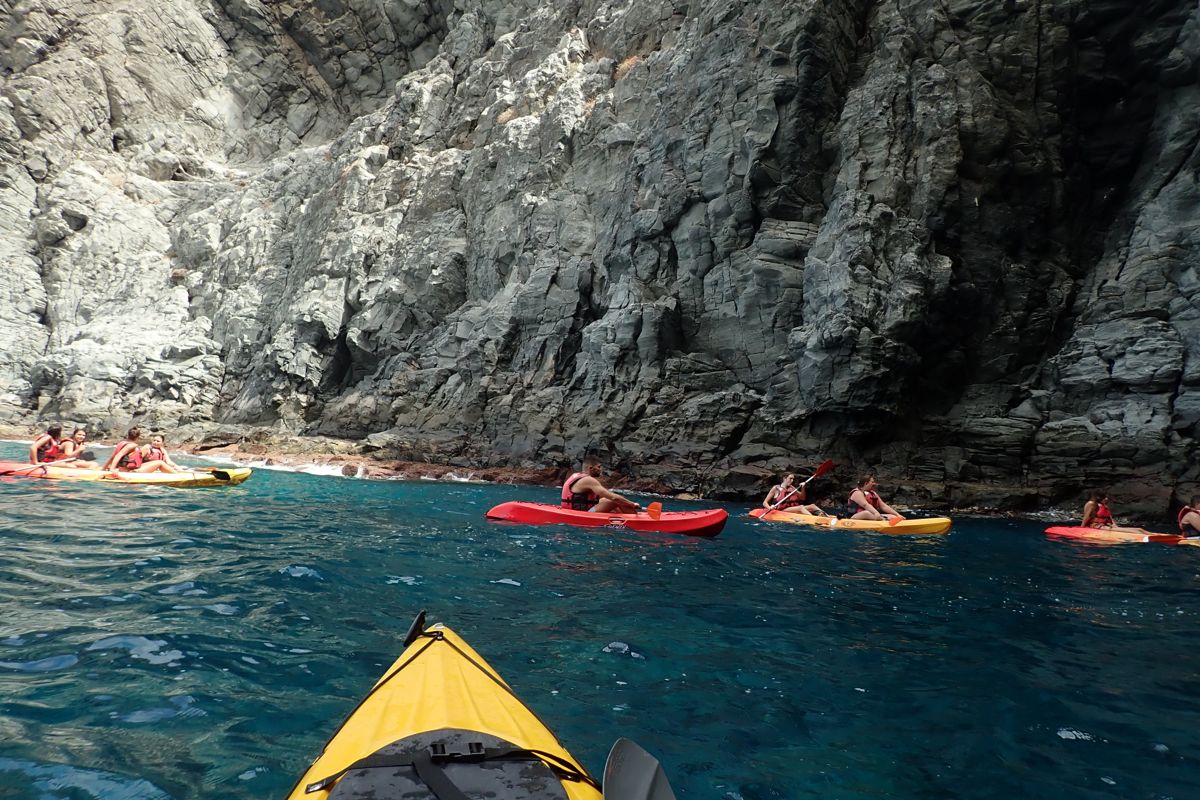 Personas haciendo kayak junto a acantilados en la costa de Tenerife.
