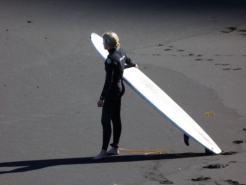 Surfero en la arena con tabla en Playa de Tenerife.