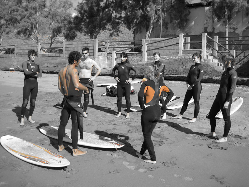 Grupo de personas con trajes de neopreno recibiendo instrucciones en una playa de Tenerife.