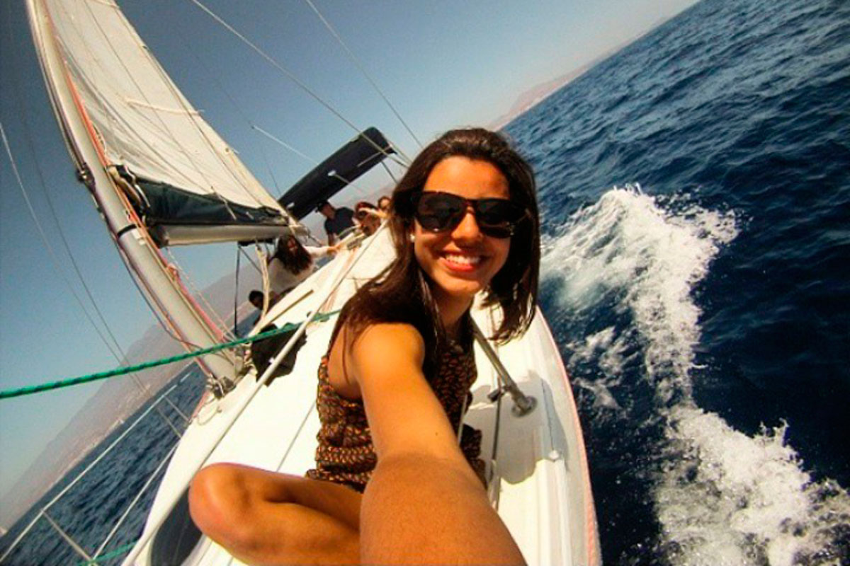 Persona sonriendo en un velero navegando cerca de la costa de Tenerife.
