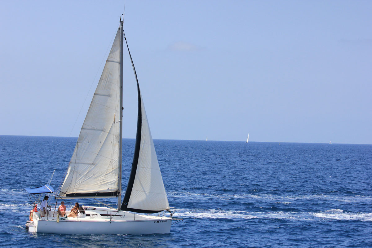 Velero navegando por las aguas de Tenerife con cielo despejado.