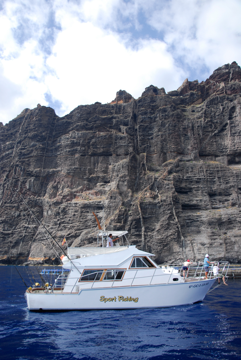 Barco de pesca deportiva frente a los acantilados de Los Gigantes, Tenerife.