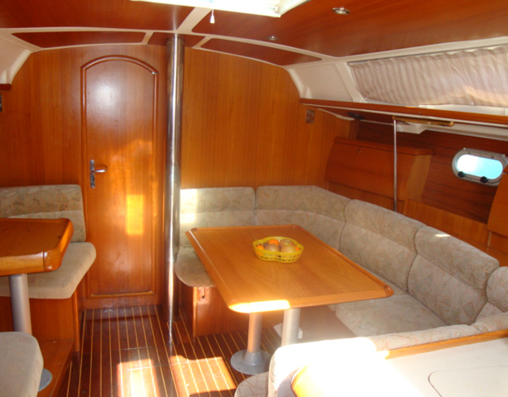 Interior de un yate con mesa de madera y asientos acolchados en Tenerife.