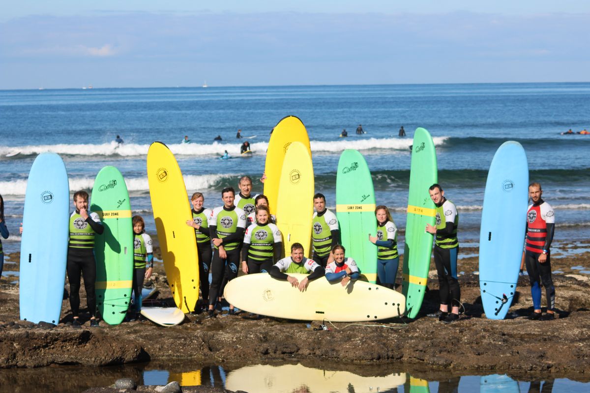 Grupo de surfistas con tablas de colores en la playa de Tenerife.