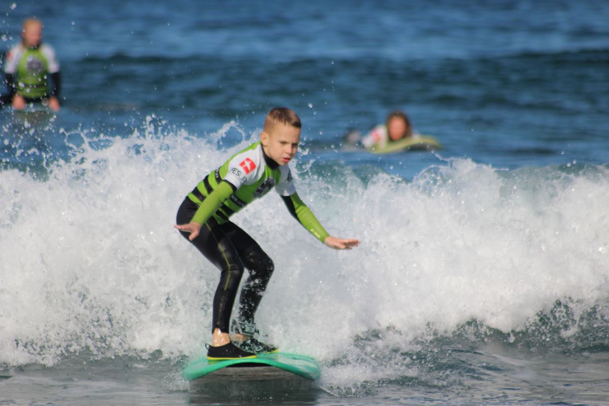 Niño haciendo surf en una ola pequeña en Tenerife.