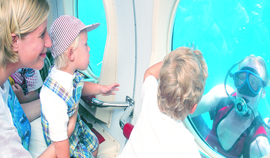 Familia observa buzo desde submarino en Tenerife.