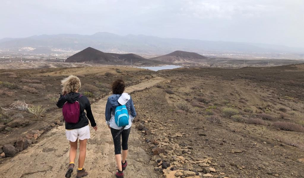 Dos personas caminando por un sendero en el paisaje de Tenerife.