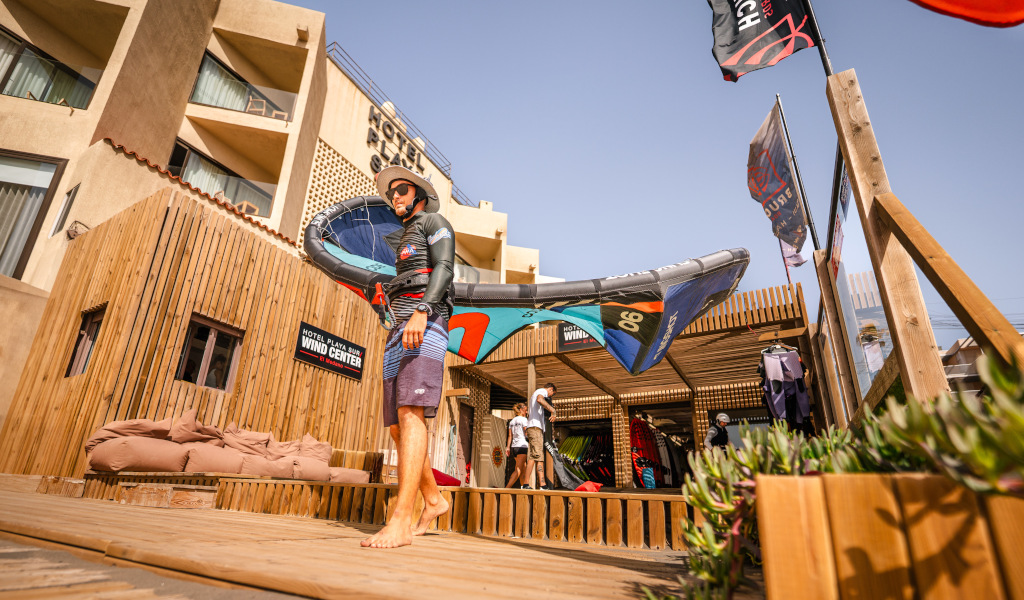 Persona sosteniendo equipo de windsurf en Hotel Playa Sur en Tenerife.