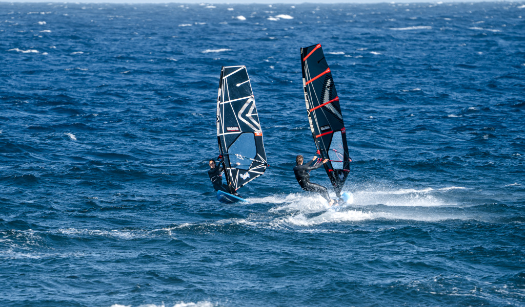 Dos personas practicando windsurf en el mar de El Médano, Tenerife.