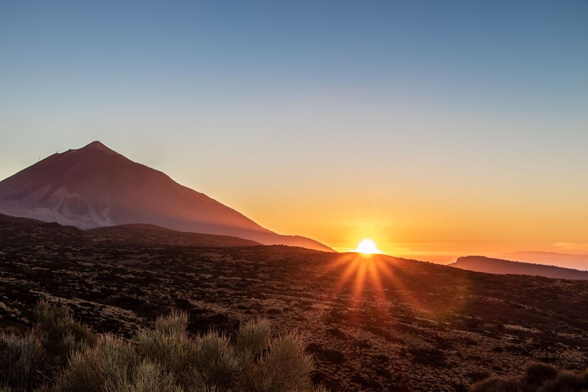 Amanecer en el Teide, Tenerife, con el sol asomando tras el horizonte.