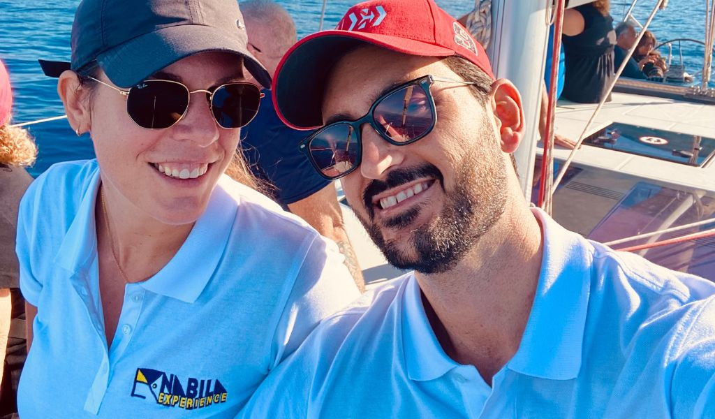 Personas sonriendo en un barco en Tenerife, con logotipo de Anaga Experience en camiseta.