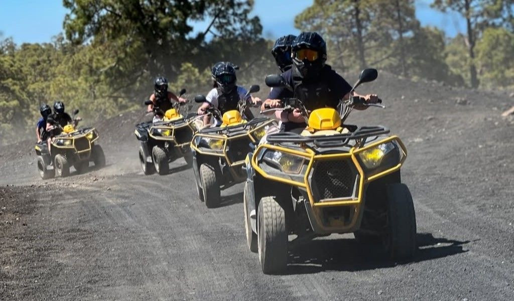 Personas conduciendo vehículos todoterreno en un camino de tierra en Tenerife.