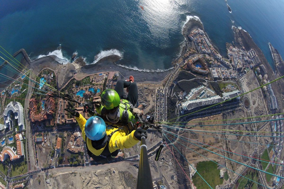 Parapente sobre Costa Adeje en Tenerife con vista al océano y la costa.