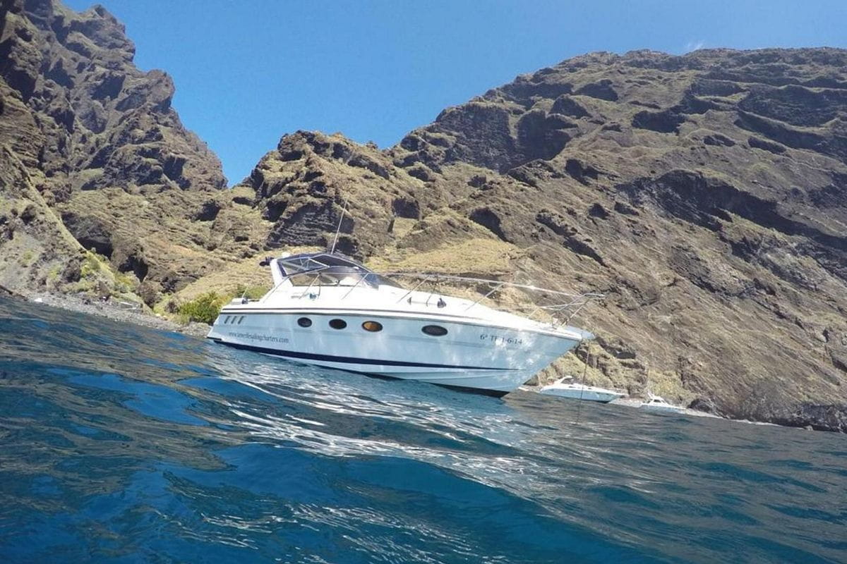 Barco anclado frente a los acantilados en Tenerife.