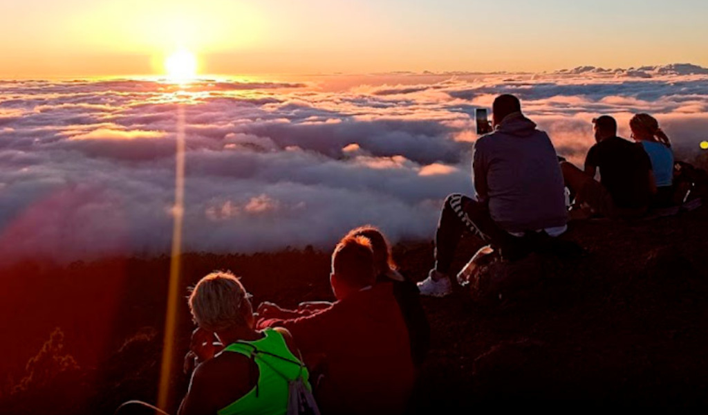 Personas disfrutando del atardecer sobre las nubes en el Teide, Tenerife.