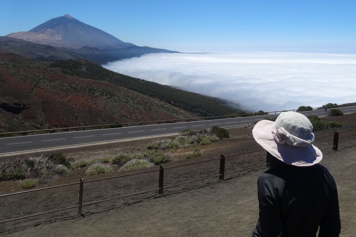 Persona con sombrero observando el Teide y el mar de nubes en Tenerife.