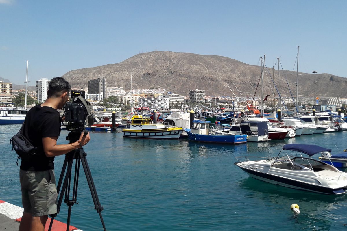 Camarógrafo filmando barcos en el puerto de Los Cristianos, Tenerife.