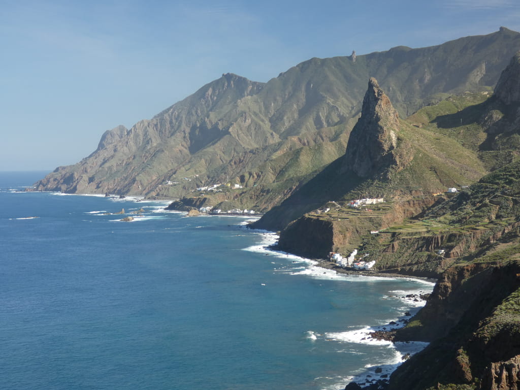Costa montañosa de Tenerife con aguas azules y acantilados verdes.