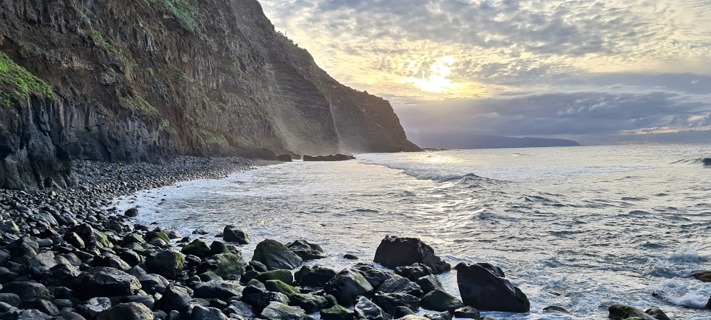 Costa rocosa al atardecer en Tenerife con acantilados y mar en calma.