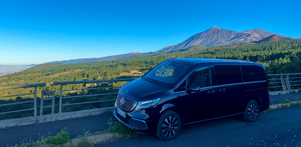 Vehículo negro con fondo del Teide en Tenerife bajo un cielo despejado.
