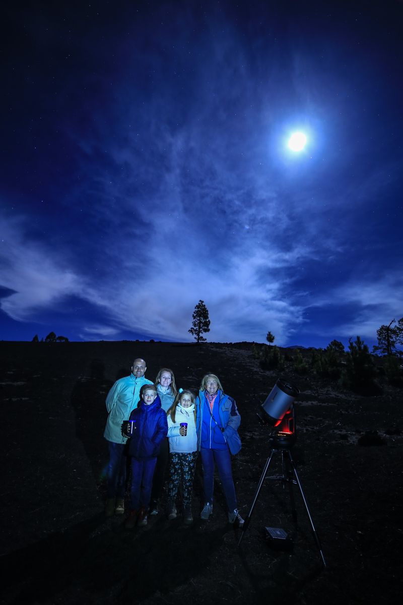 Grupo de personas con telescopio observando el cielo nocturno en Tenerife.
