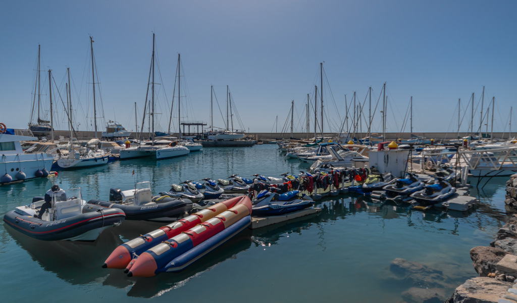 Motos de agua y barcos atracados en el puerto de Tenerife.