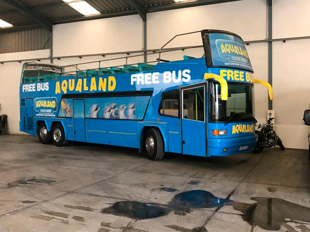 Autobús azul de Aqualand Costa Adeje, Tenerife, estacionado en un garaje.