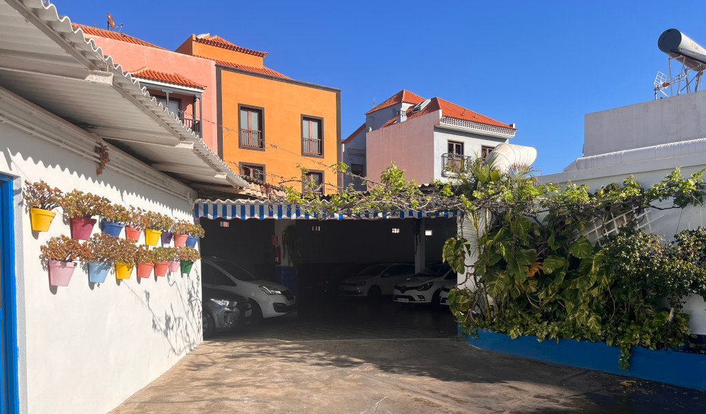Estacionamiento con plantas y macetas coloridas en Tenerife.