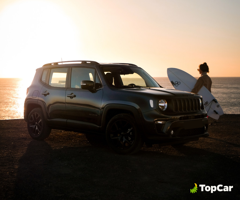 Coche estacionado al atardecer junto a surfista en la costa de Tenerife.