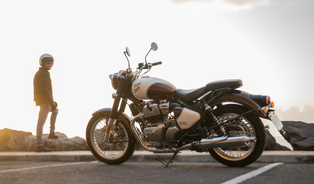 Motocicleta parqueada con persona de pie en el fondo al atardecer en Tenerife.