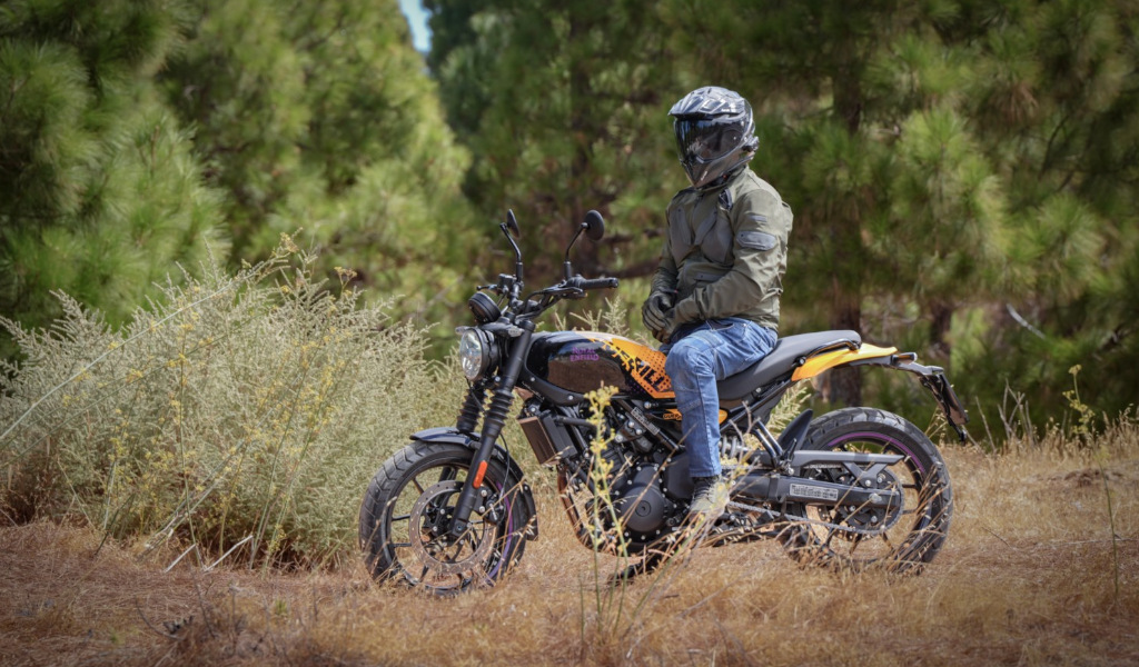Persona con casco sentado en una motocicleta en un camino forestal en Tenerife.