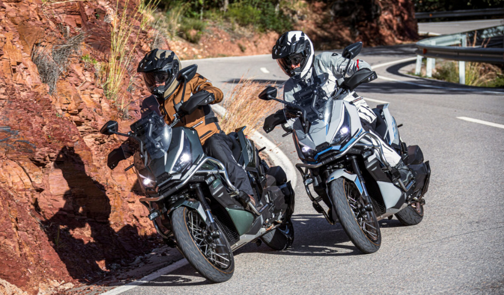 Dos motociclistas en carretera curva con fondo rocoso en Tenerife.