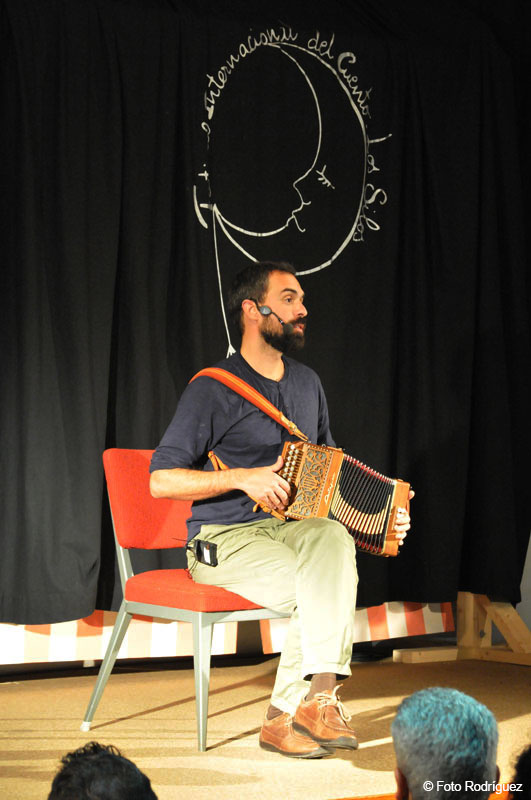 Hombre tocando un acordeón sentado en una silla durante un evento cultural en Tenerife.