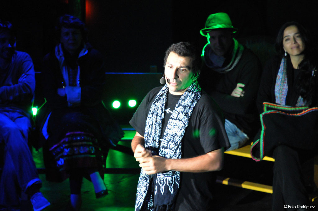 Persona hablando en un escenario iluminado en un evento cultural en Tenerife.