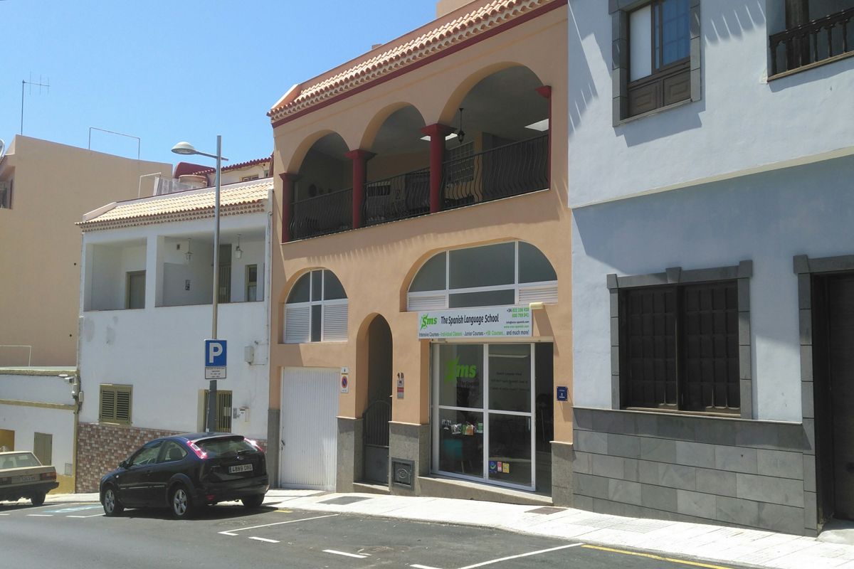Fachada de The Spanish Language School en Tenerife, con coches aparcados enfrente.