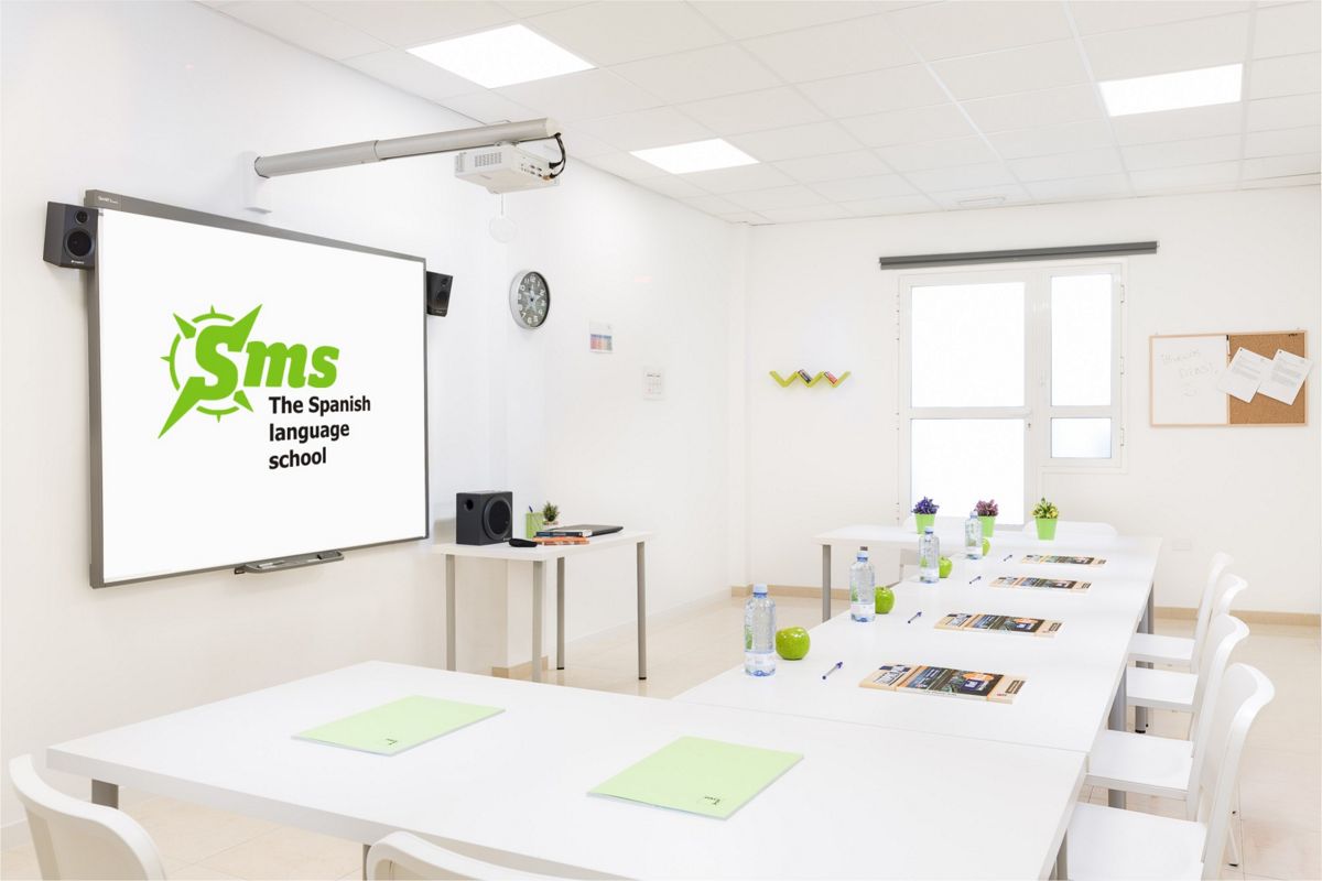 Aula de escuela de idiomas en Tenerife con logotipo de The Spanish language school en pantalla.
