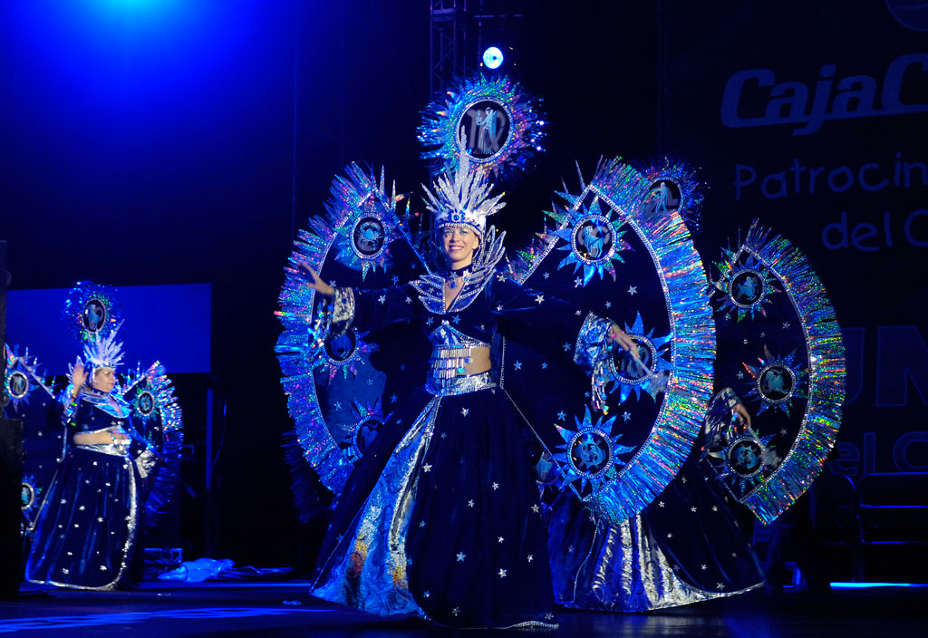 Mujeres en trajes de fantasía brillantes bailando en un escenario en Tenerife.