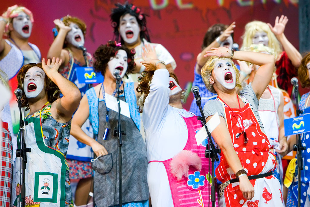 Personas con disfraces y caras pintadas cantando en un evento en Tenerife.