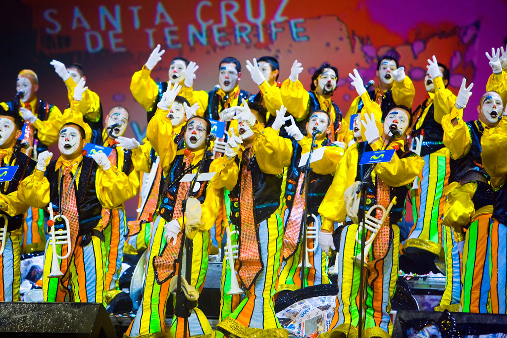 Personas disfrazadas de mimos coloridos cantan en el Carnaval de Santa Cruz de Tenerife.