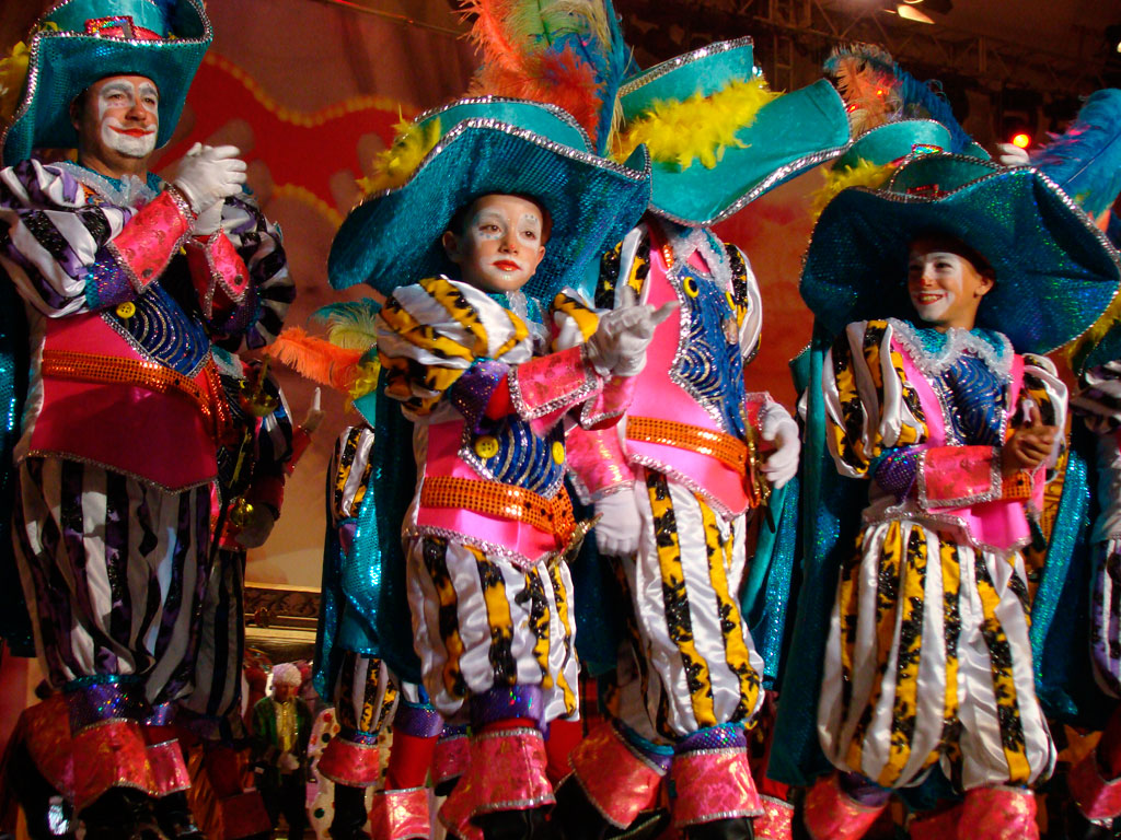 Personas disfrazadas en el carnaval de Tenerife, vistiendo trajes coloridos y brillantes.