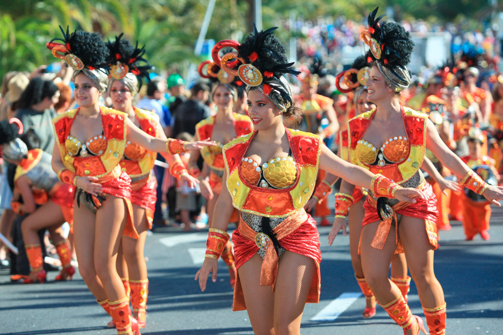 Personas desfilando en coloridos trajes en el Carnaval de Tenerife.