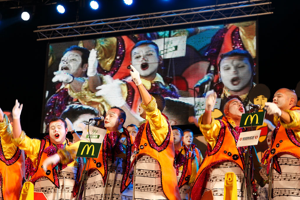 Actuación musical durante un carnaval en Tenerife con coloridos disfraces y canto en grupo.