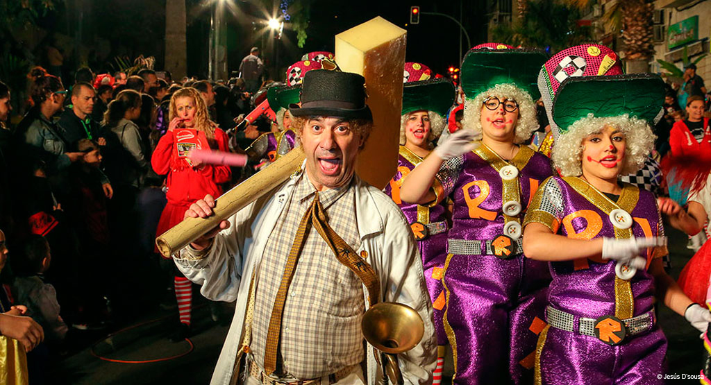 Personas en disfraces coloridos desfilando en un carnaval en Santa Cruz de Tenerife.