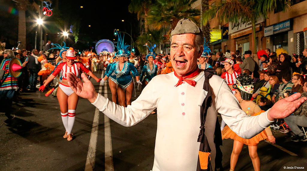 Desfile nocturno de Carnaval en Santa Cruz de Tenerife con disfraces coloridos.