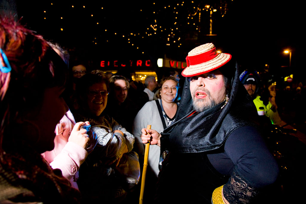 Persona disfrazada y grupo celebrando en la noche en Santa Cruz de Tenerife.