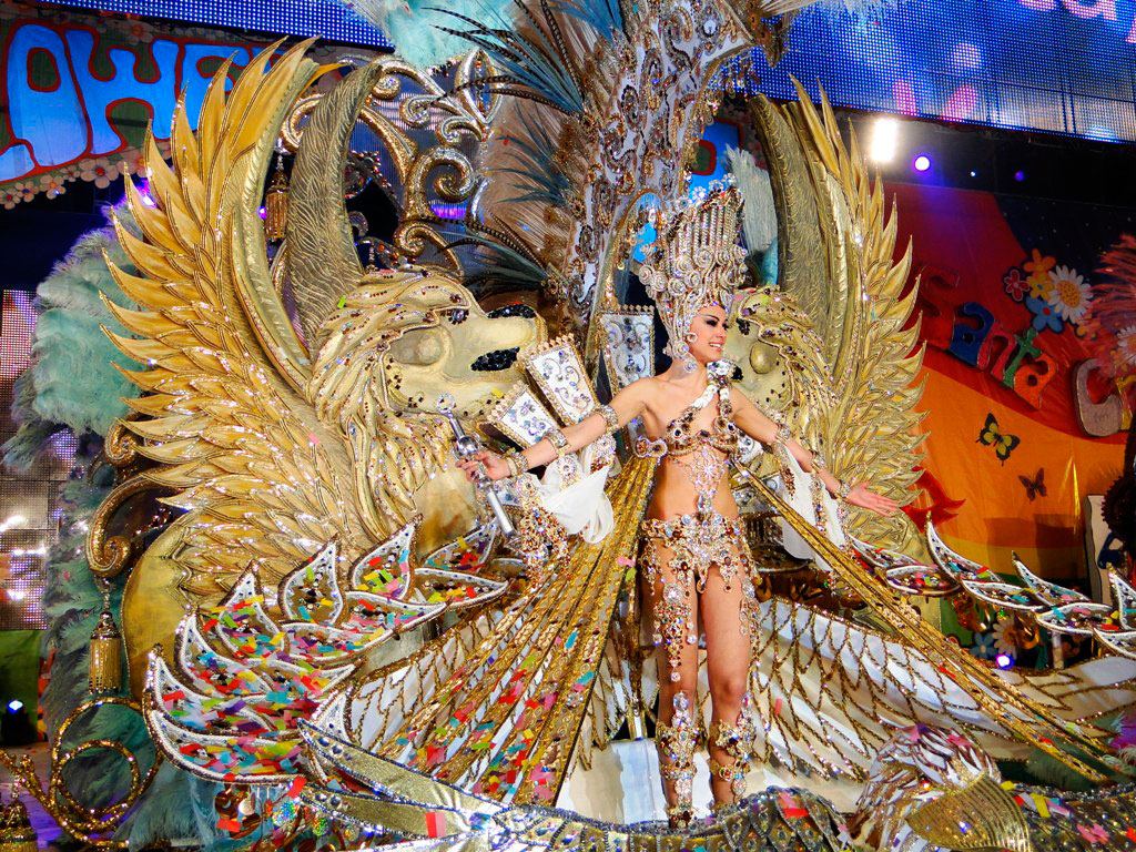 Traje festivo en el Carnaval de Santa Cruz de Tenerife con leones dorados y plumas.