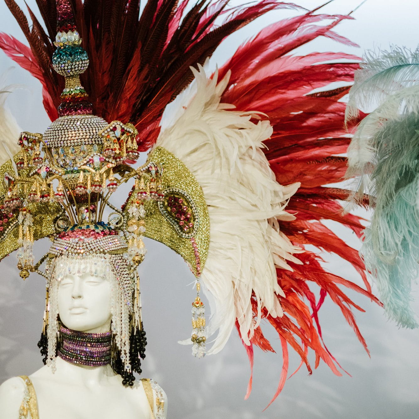 Maniquí con elaborado tocado de plumas y cuentas brillantes en el Carnaval de Tenerife.