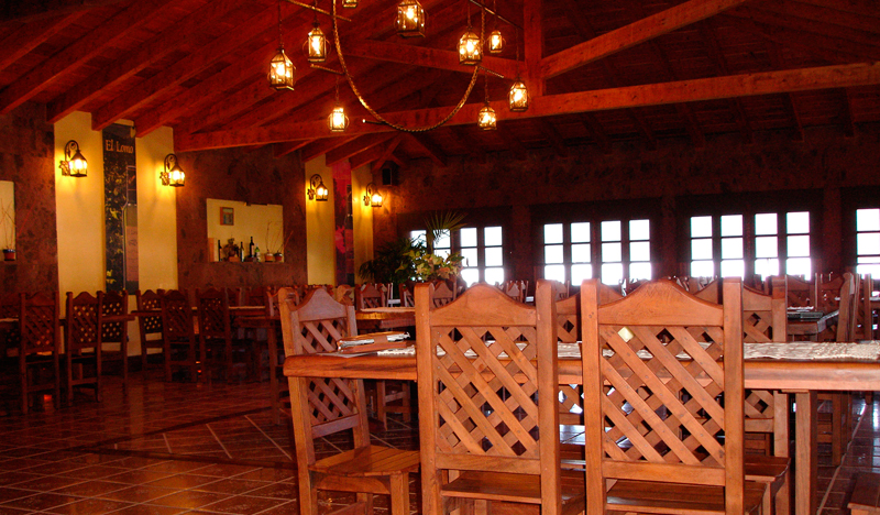 Restaurante con mesas y sillas de madera iluminado en El Lomo, Tenerife.