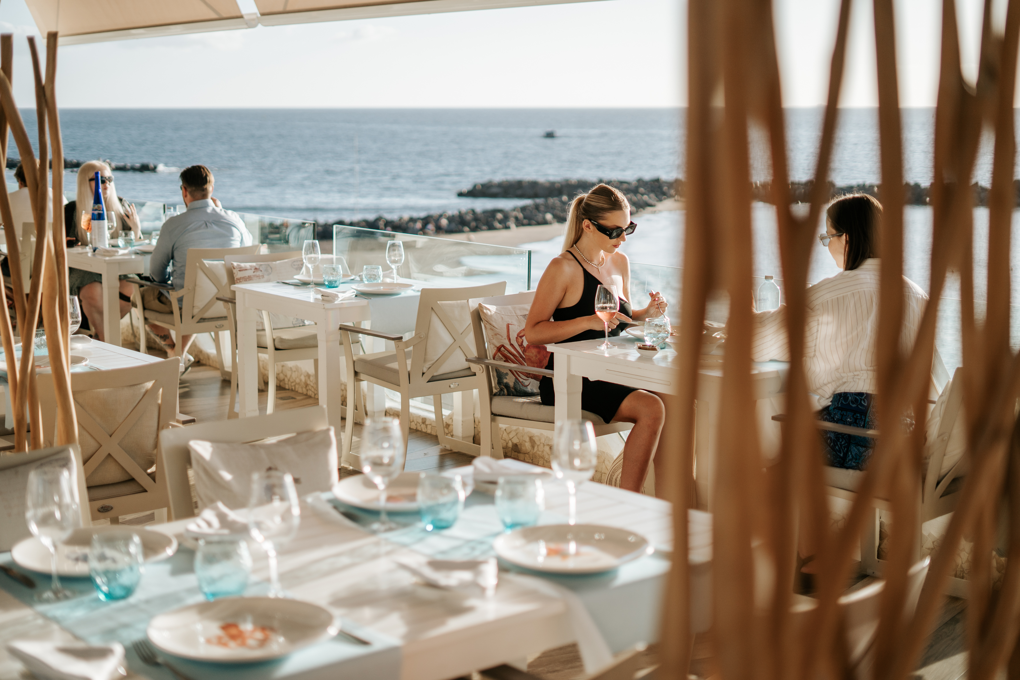 Personas cenando en un restaurante con vista al mar en Tenerife.