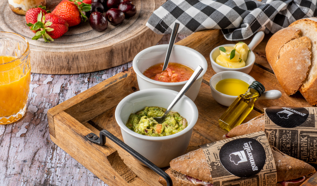 Desayuno con frutas, jugo de naranja, guacamole, pan y aceite de oliva en Tenerife.